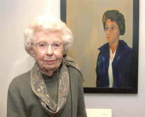 Leola Bergmann in front of her portrait of May Brodbeck in the Iowa Women's Archives, University of Iowa, Iowa City, Iowa, Mar. 4, 2002 