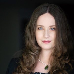 Young woman with long brown hair looking directly at camera