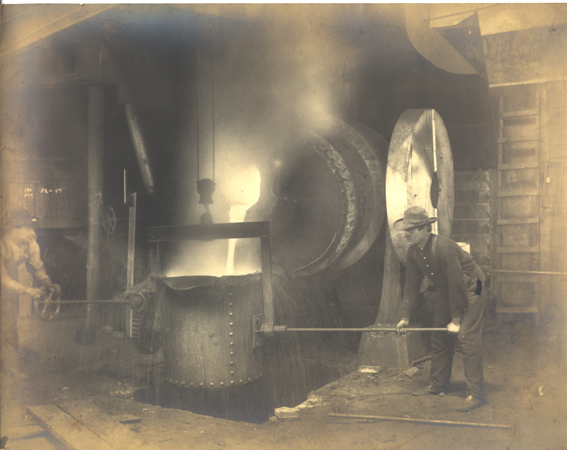 Steel worker pouring molten ore