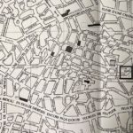 Black and white city map with many curving streets, seen from far above. Street names are not legible.