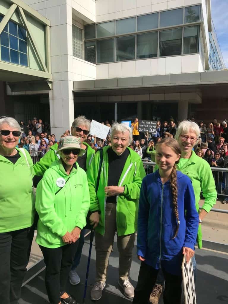 A group of older women pose with climate activist Greta Thunberg in Iowa City.