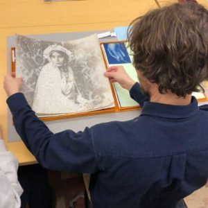 Student looking at paper art