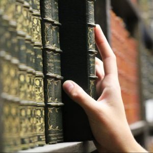 Hand Reaching to a book on a shelf