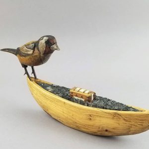 Artist book of wooden bird on wood boat containing metal type